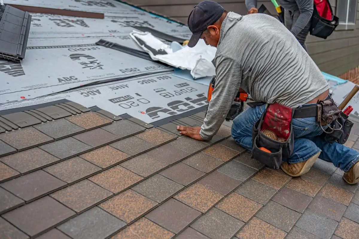 Roofing installer fastening shingles over new underlayment in Toms River, NJ
